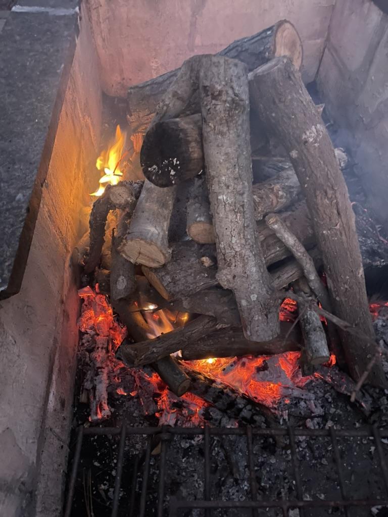 A fire pit with firewood and flames

AI-generated content may be incorrect.