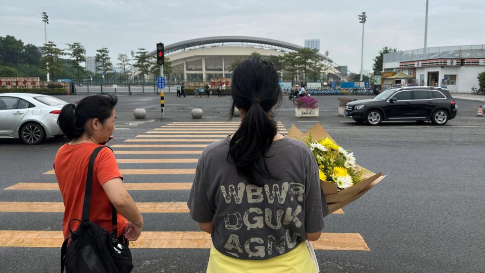 Une femme tient un bouquet de fleurs alors qu'elle se dirige vers le centre sportif o a eu lieu une attaque meurtrire  la voiture-blier. Zhuhai, Chine, le 13 novembre 2024.