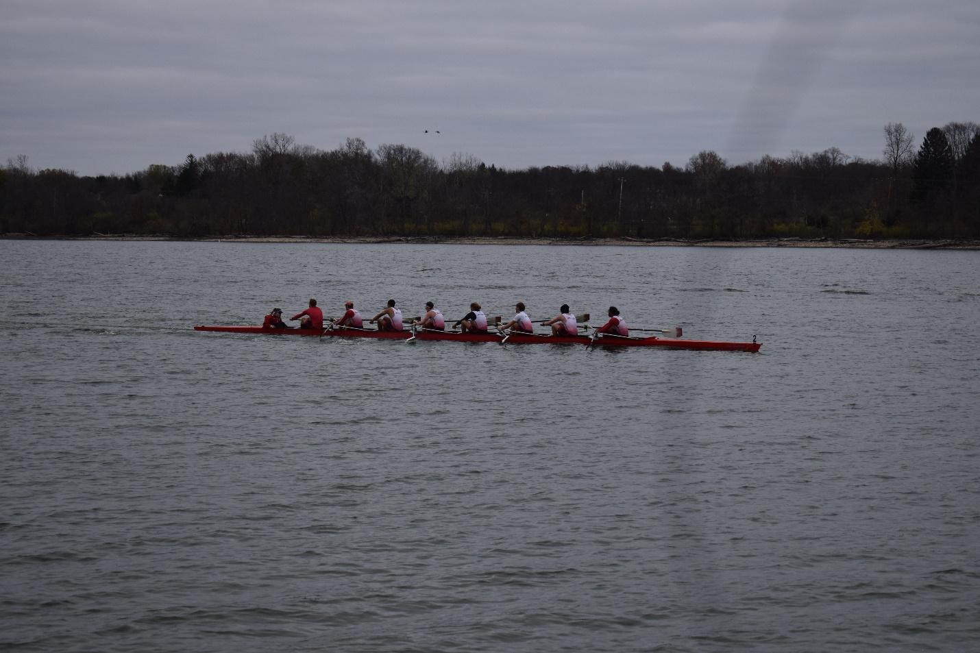 A group of people rowing on a lake

Description automatically generated