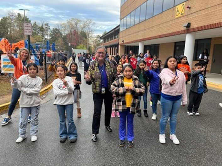 Dr. Reid dancing with students at Bailey's Upper Elementary School as part of a Move with Compassion flash mob. 