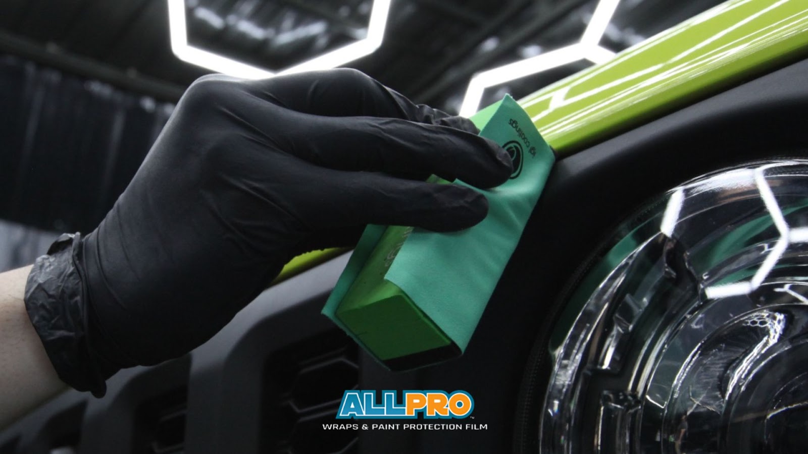 AllPro Wraps technician applying ceramic coating to a car exterior