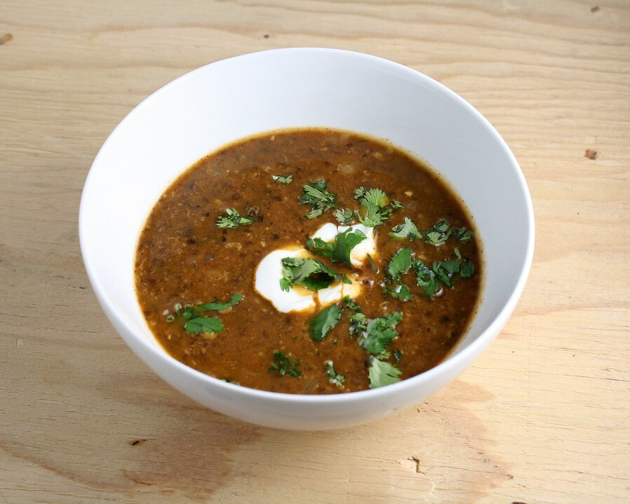 Bowl of Sopa Negra garnished with fresh cilantro.