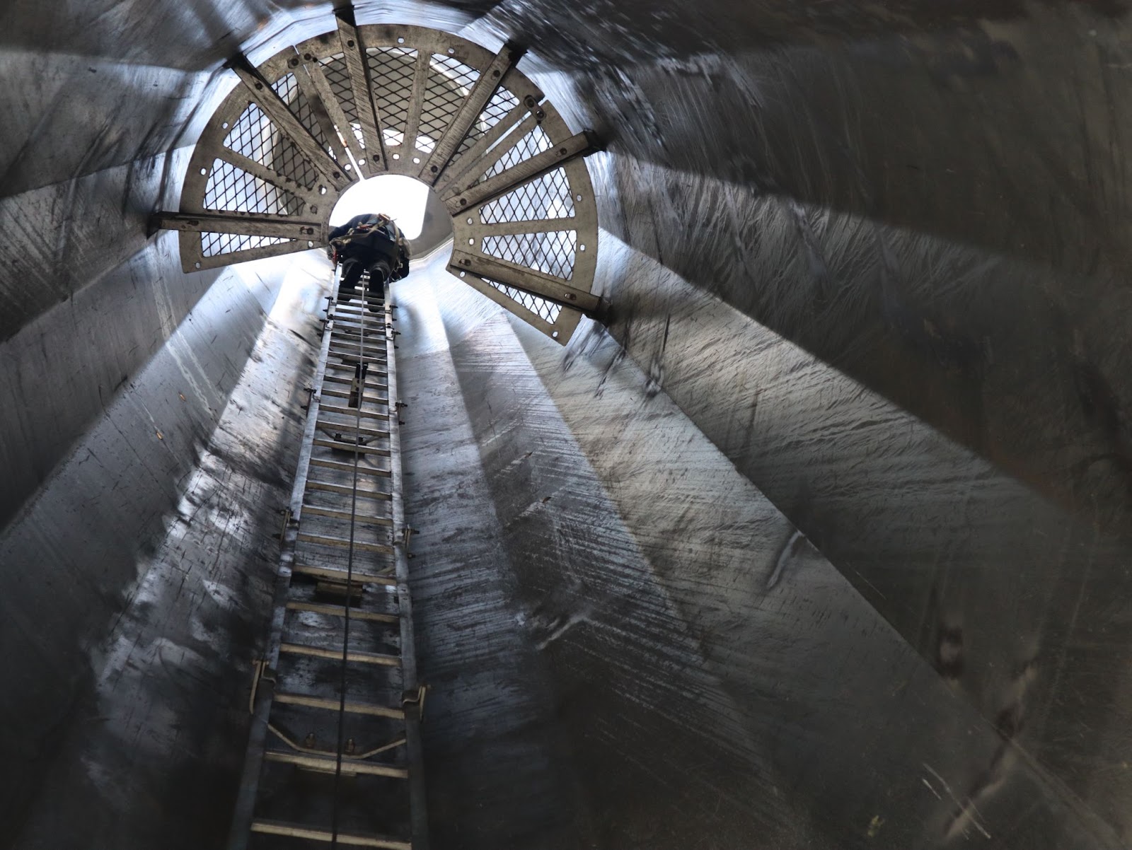 Pinnacle Career Institute student climbing the inside of the monopole to mimic a wind turbine tower