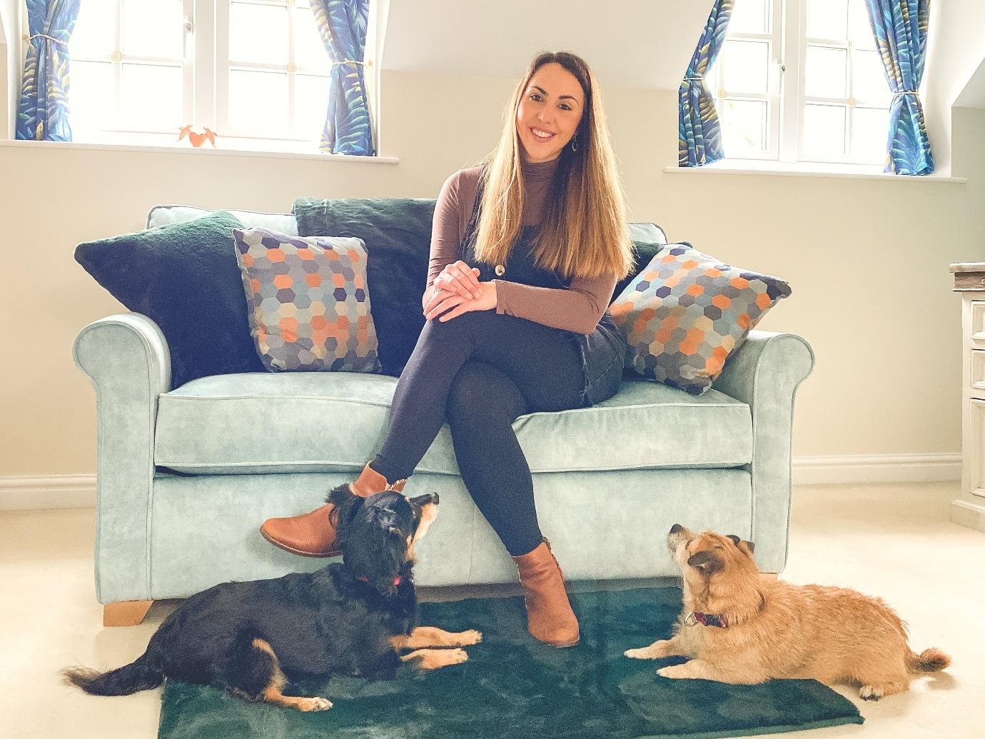 A person sitting on a couch with dogs

Description automatically generated with medium confidence