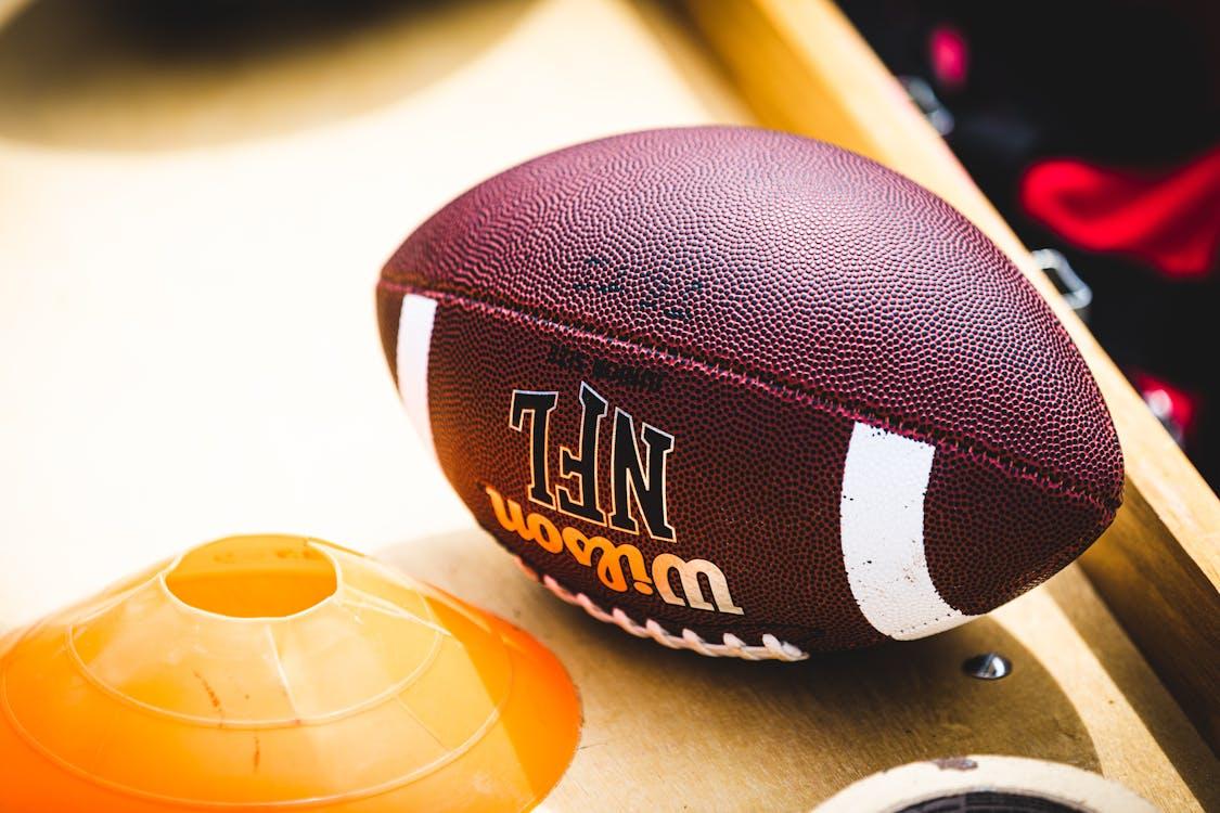 Free Brown and White Football on White Table Stock Photo