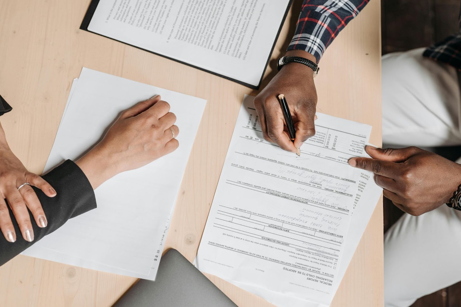 Man signing paperwork on desk