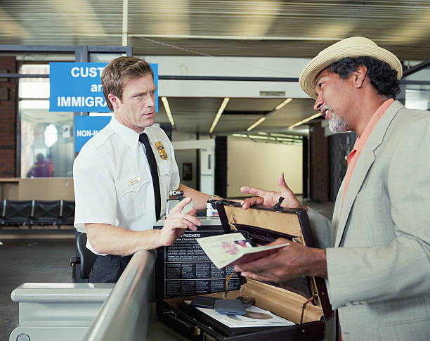 U.S. Customs officer reviewing immigrant visa at port of entry