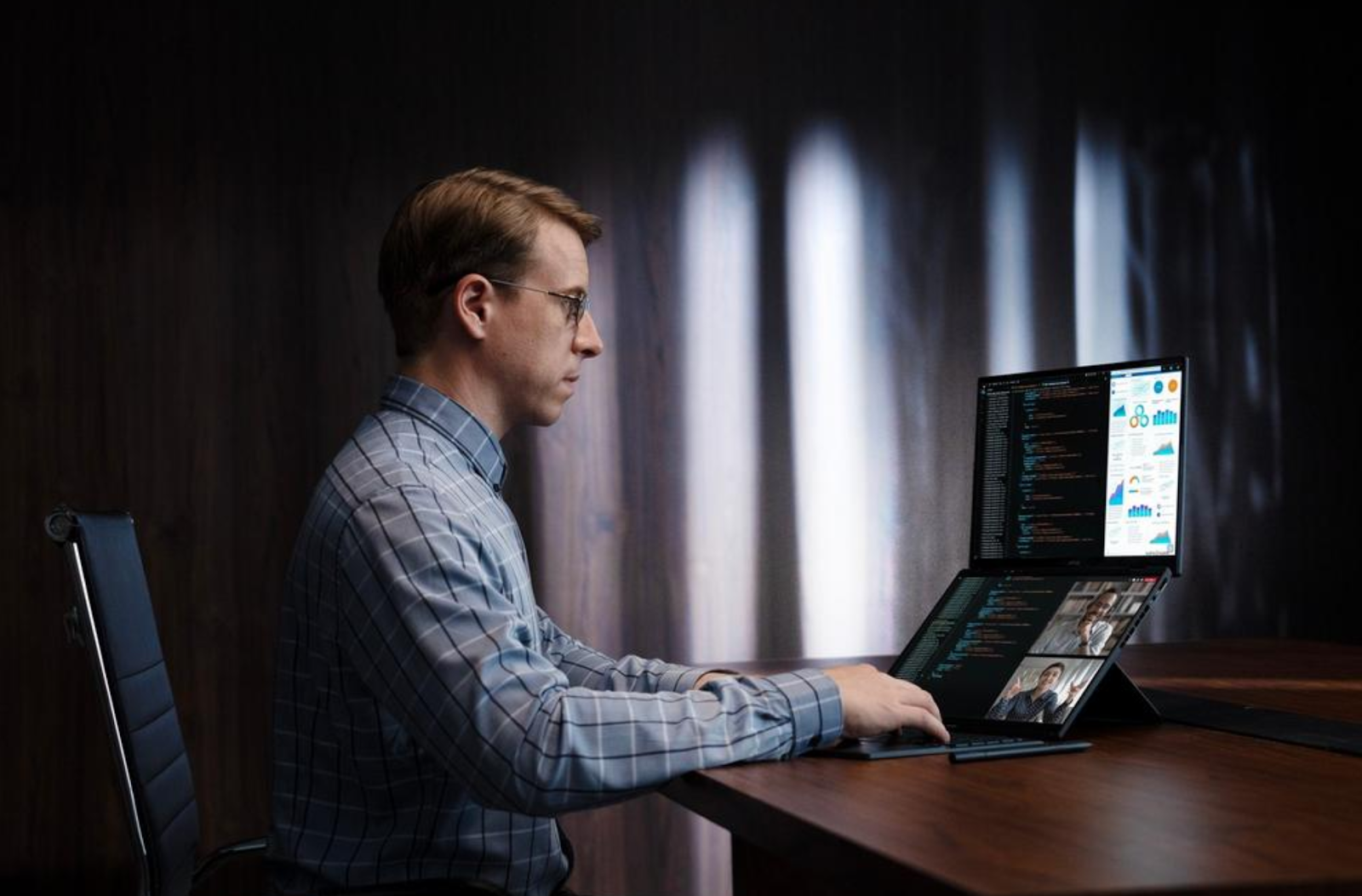 A person sitting at a desk using a computer

Description automatically generated