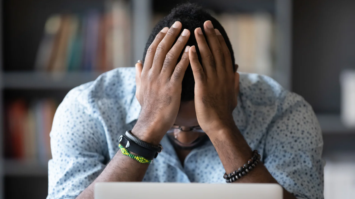 (Frustrated man with head in hands, symbolizing the emotional toll of civil rights violations or false accusations.)
