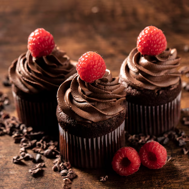 a group of chocolate cupcakes with raspberries