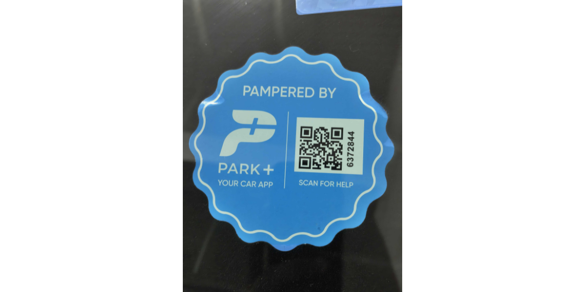 A Park+ QR Code sticker on a car's windshield. 