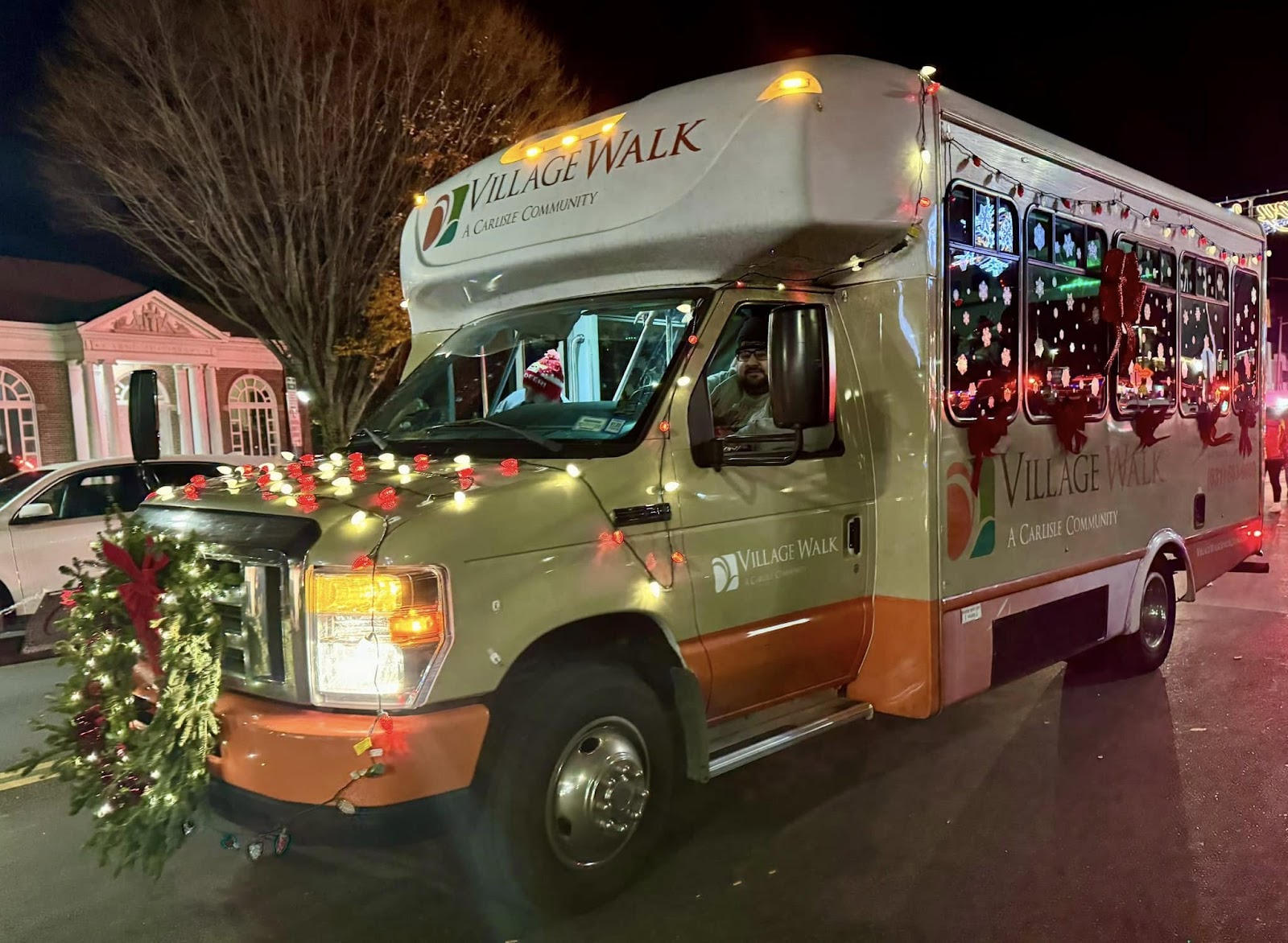 Village Walk assisted living bus with Christmas ornaments and lights hanging from it