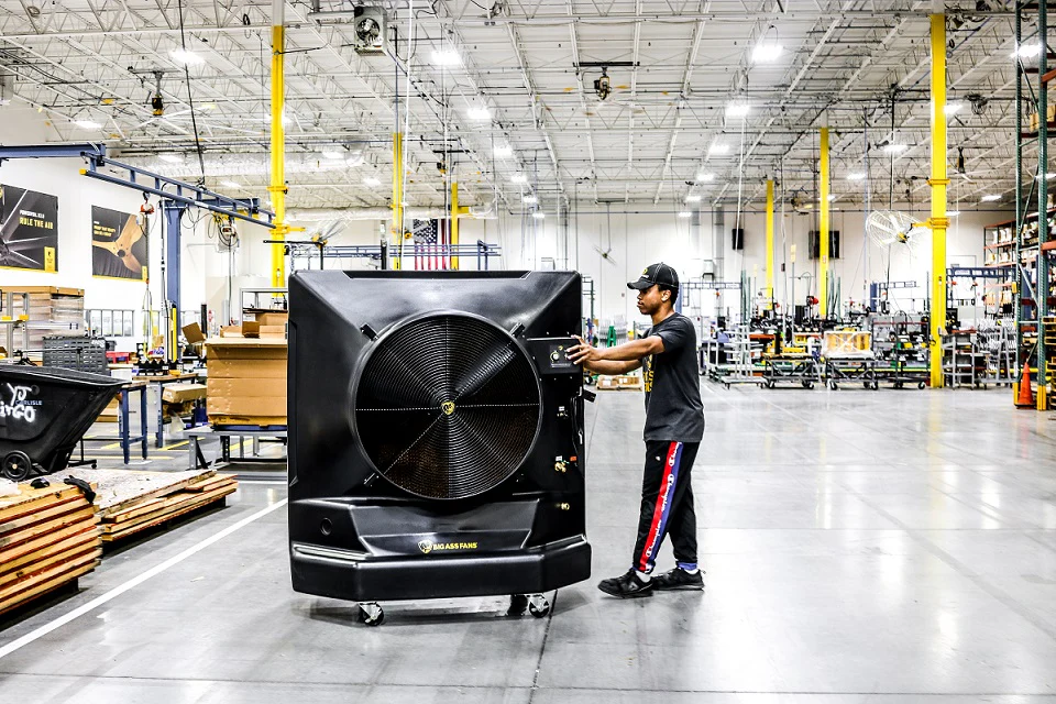 A portable evaporative cooler set up on a warehouse floor.