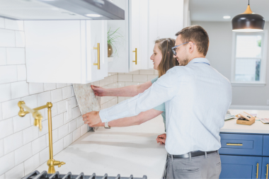 factors that affect the cost of a walk in closet remodeler and homeowner examining kitchen backsplash custom built michigan