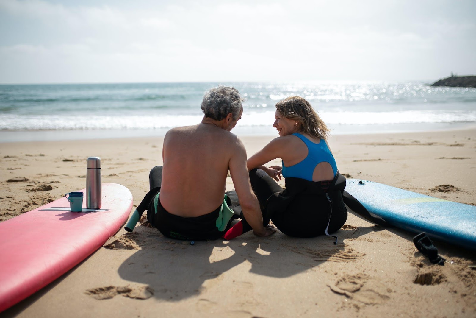 A person and person sitting on the beach

Description automatically generated