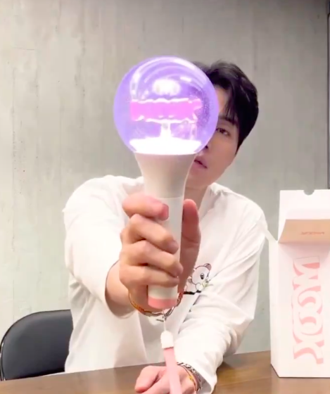 This  contain of image of Lee Dong holding Wook's lightstick