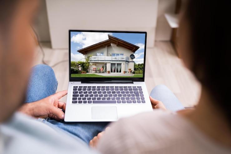 A couple looking at a picture of a villa on the computer