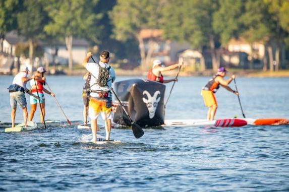 A group of people on paddle boards Description automatically generated