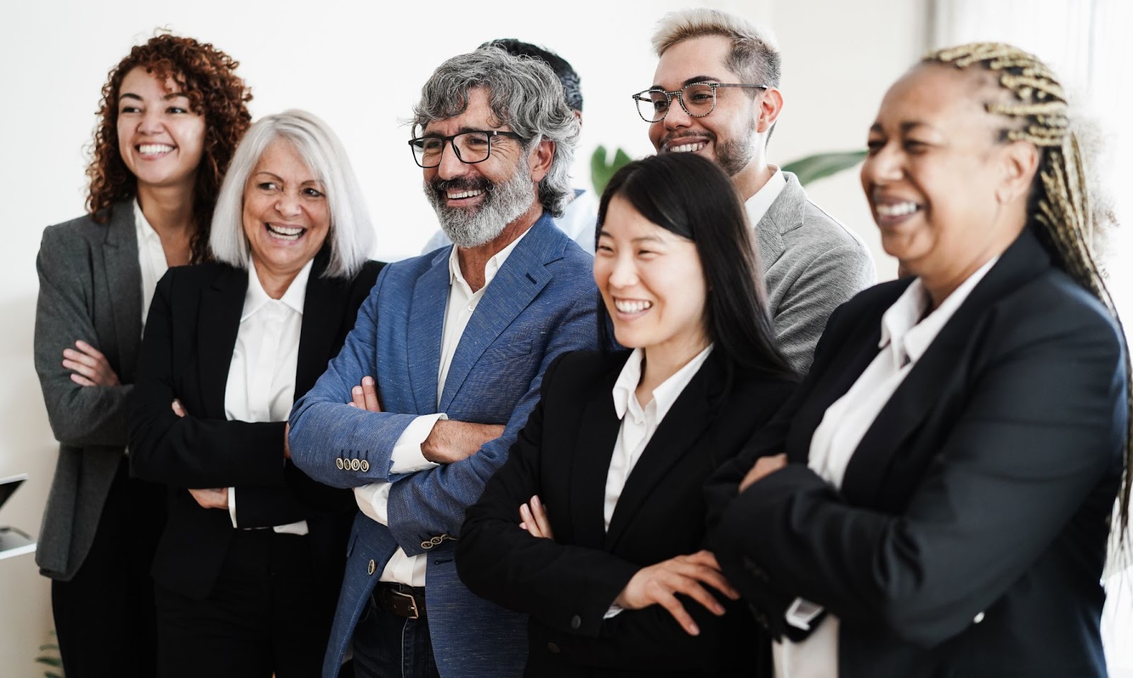 Men and women in business attire and smiling. 