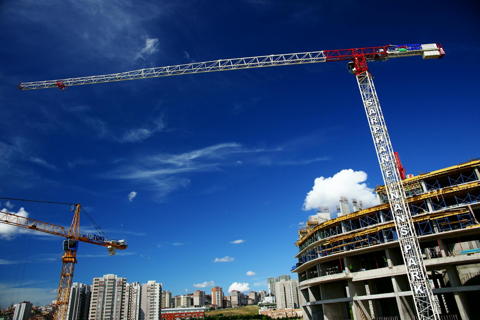 A towering crane at a construction site under a bright blue sky, representing the progress and challenges of real estate projects in Dubai.