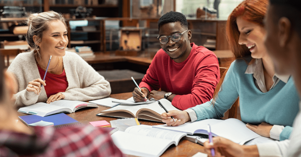 Happy college students studying together