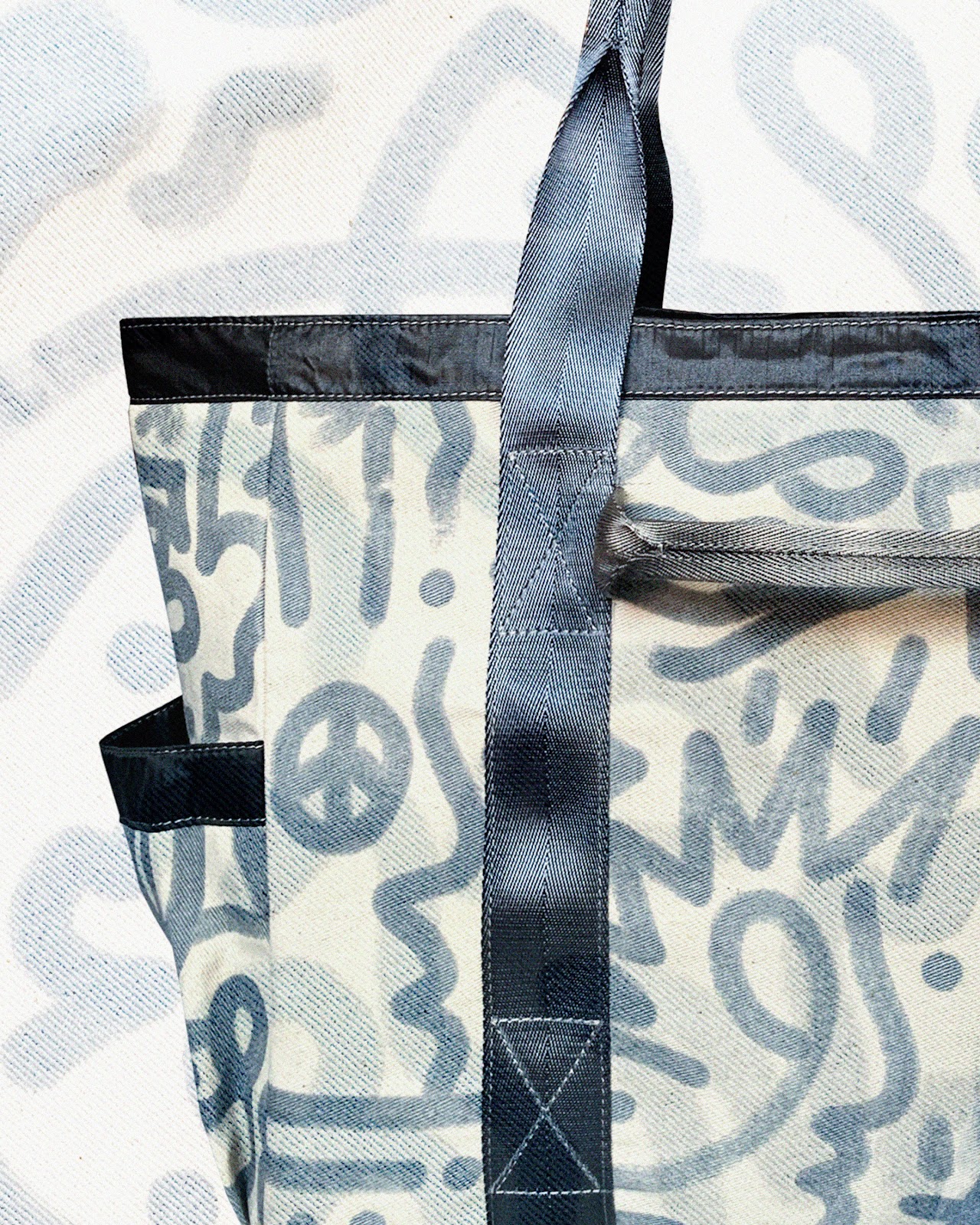 A close up of abstract blue design over white canvas on the Utility Tote.