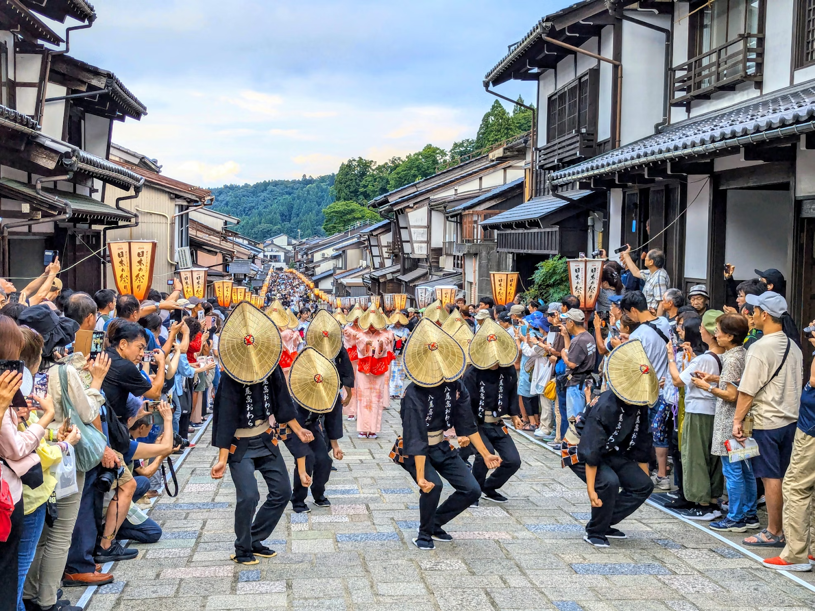 A parade happening in a small town in Toyama, cheered on by audiences on both sides of the street.