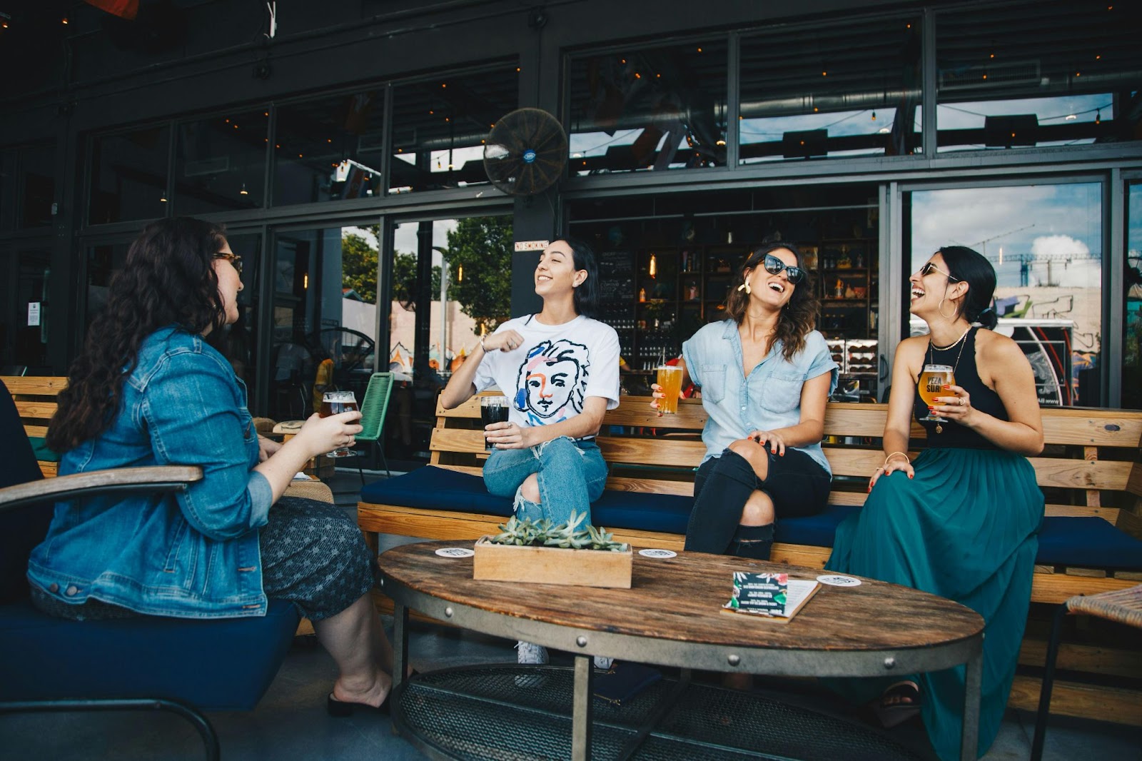 A group of women laughing and enjoying drinks