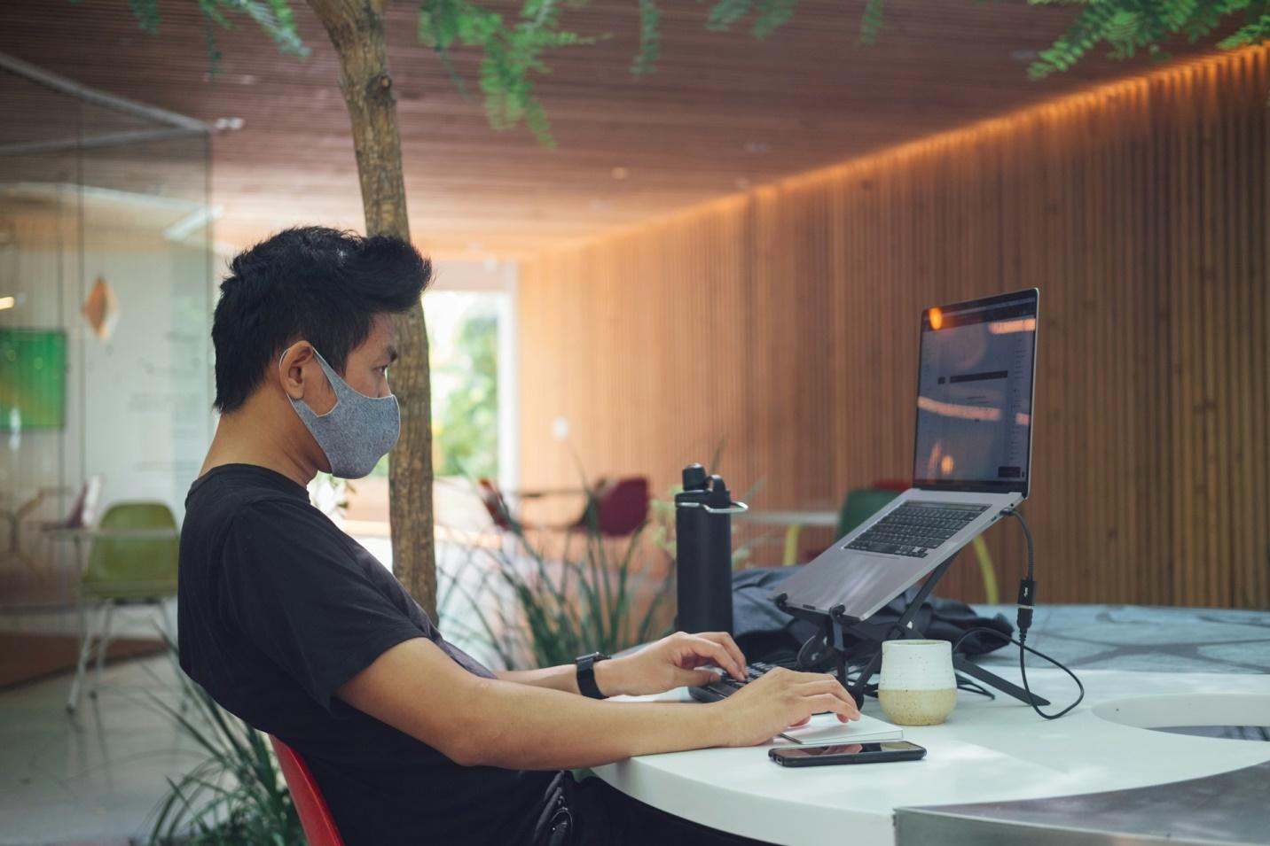 A man invested in a laptop stand for work