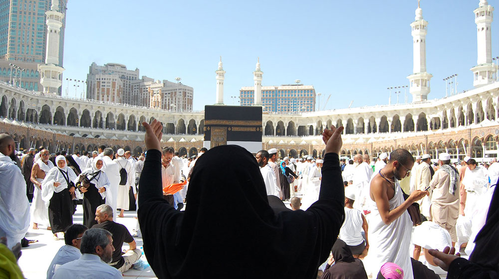 A woman offering supplication looking at the Kaaba during Umrah - (Credits ProPakistani)