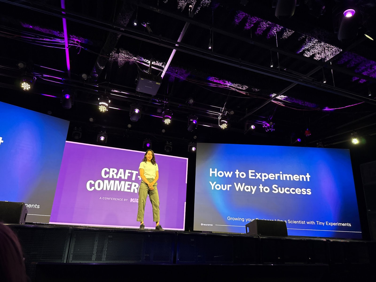 Anne-Laure Le Cunff speaking on stage at a conference with a slide behind her that reads "How to Experiment Your Way to Success"