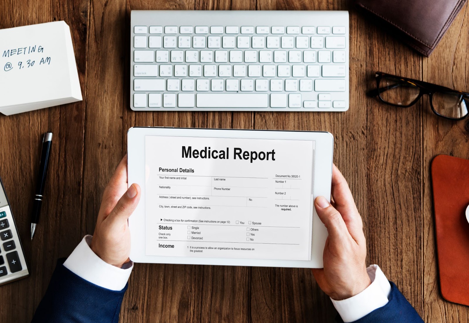 Person holding a tablet displaying a fake medical bill report at a desk