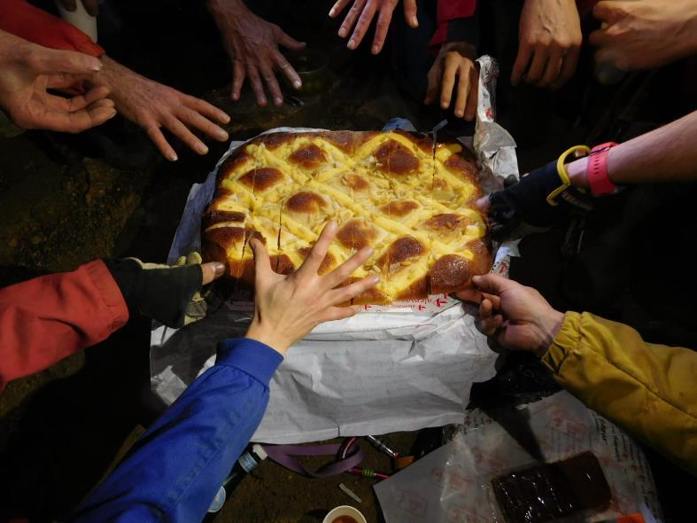 Un grupo de personas comiendo pizza

Descripción generada automáticamente con confianza baja