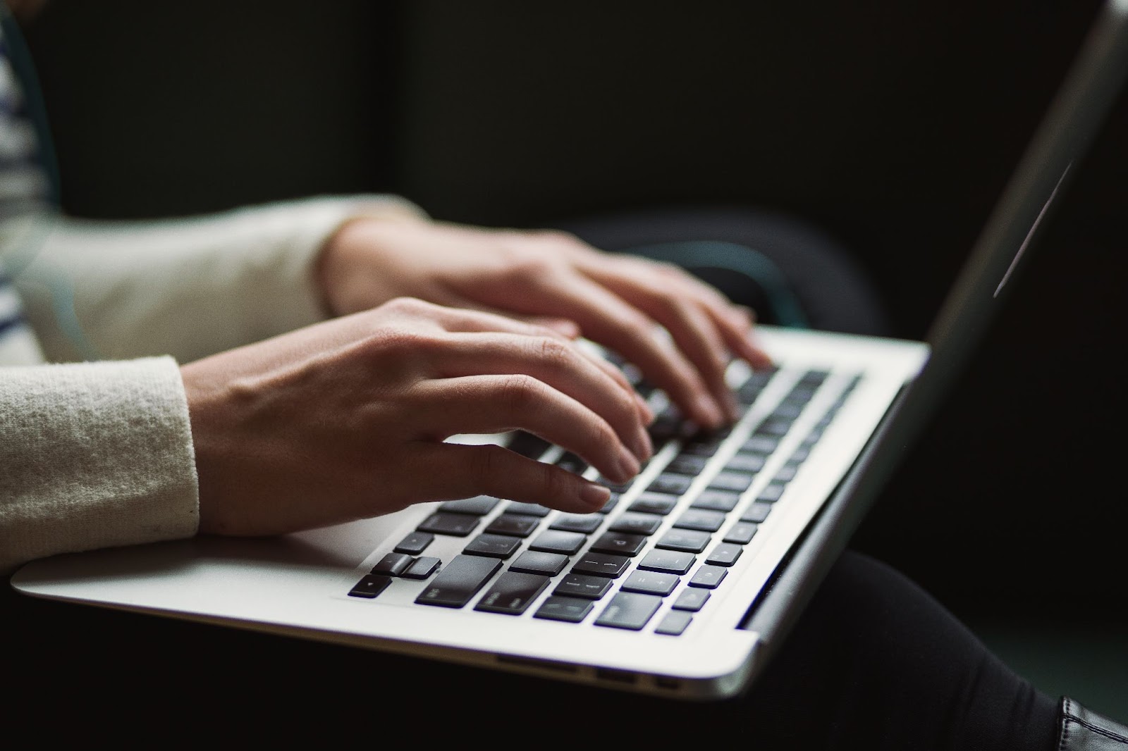 A content writer typing on a laptop.