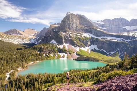 A person standing in front of a lake surrounded by mountains

AI-generated content may be incorrect.