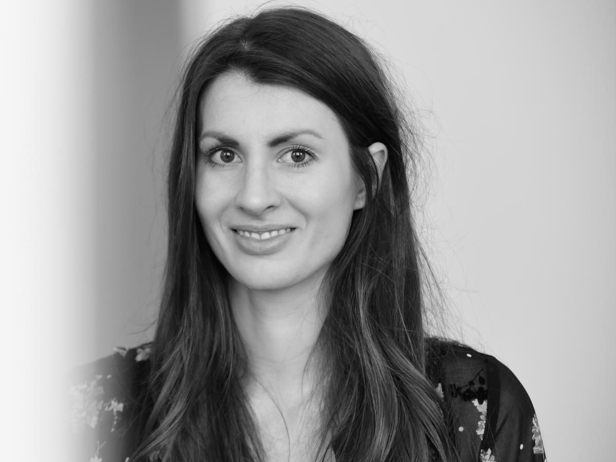 A black and white portrait photo of Laura Deschl, the designer of The Healing Imprint—garments which help with trauma recovery