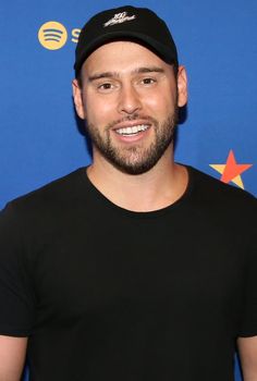 A picture of Scooter Braun wearing a black shirt and a face cap 