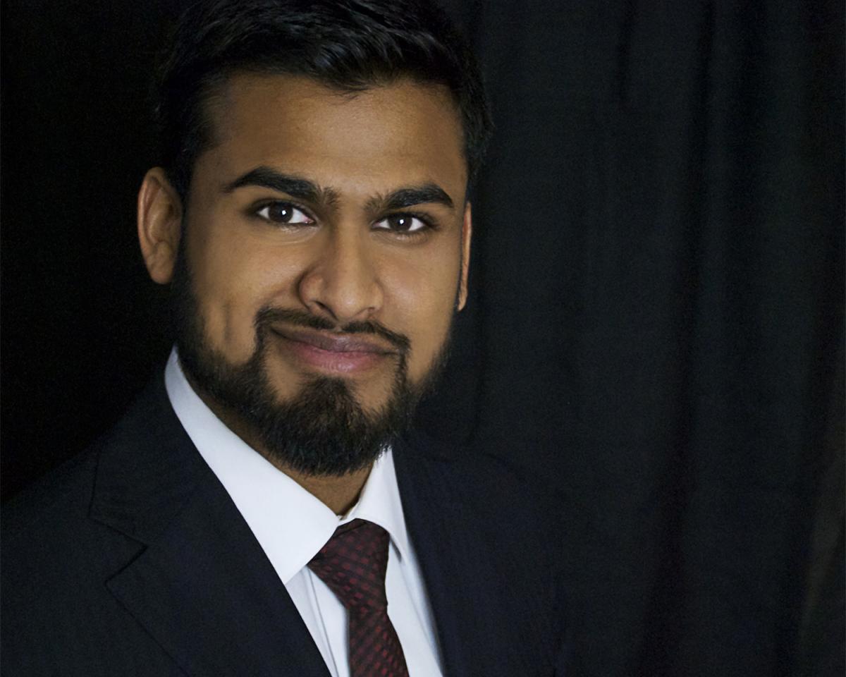 Manas S Kshirsagar in a black suit, white shirt, and tie.