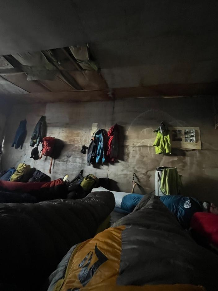 A room with sleeping bags and backpacksAI-generated content may be incorrect.
