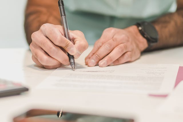 Person writing on a document