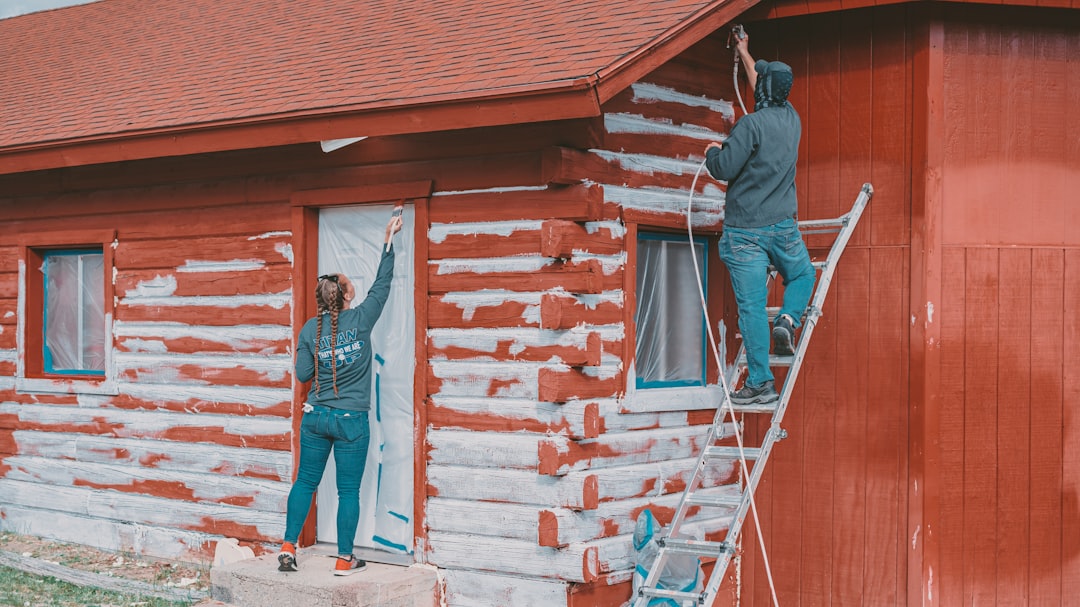 Exterior painting contractors working on a multi-story home