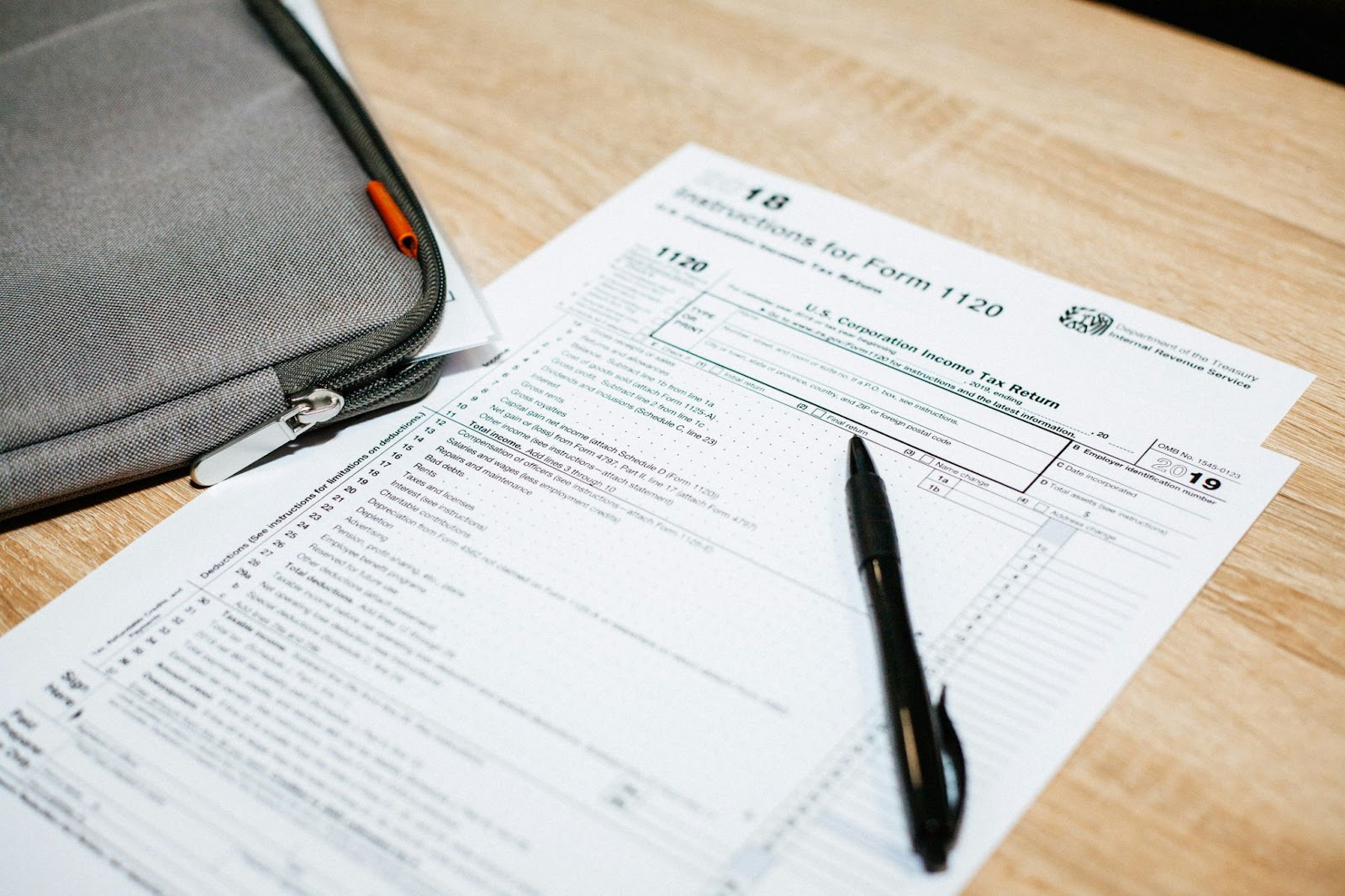 A tax form with a pen sitting on a wooden surface