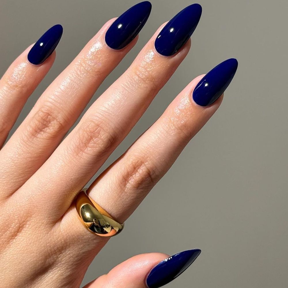 Close up of hands with blue winter nails having Dark Royal blue nails Grande Finale