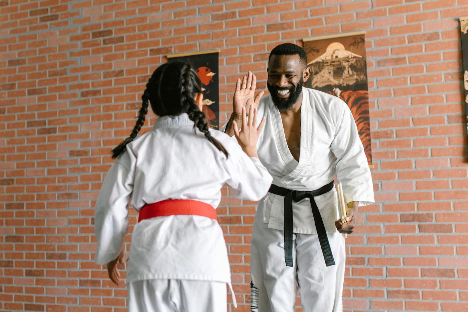 A smiling instructor high-fives a young student