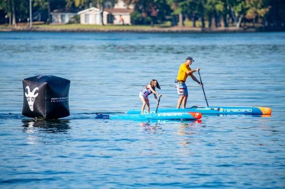 A person and a child on a paddle board Description automatically generated