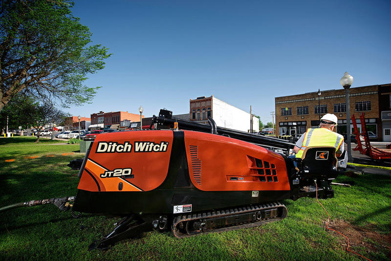 Ditch Witch JT20 directional drill operating in a grassy area, engineered for precise underground utility installations in rural environments and tight spaces, ideal for telecom companies expanding fiber-optic networks.