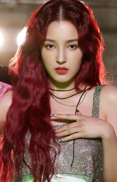 This contain MOMOLAND's Nancy  with long red hair wearing a silver top