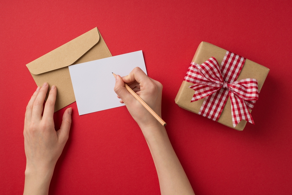 Woman writing on a blank Valentine’s Day card