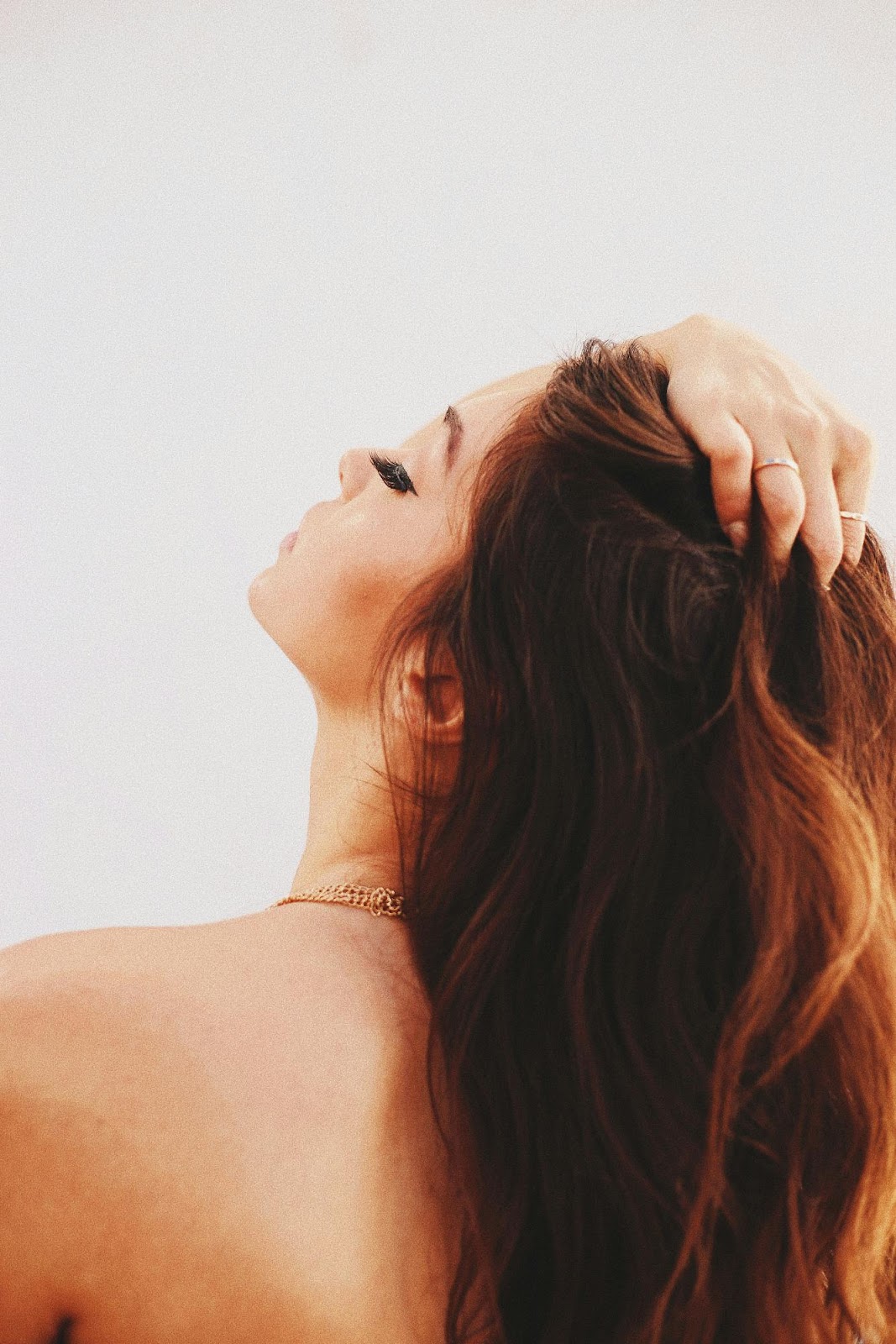 Close-up of woman running fingers through long voluminous hair