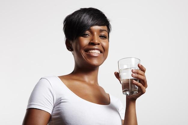 Mulher com um copo de água está sorrindo